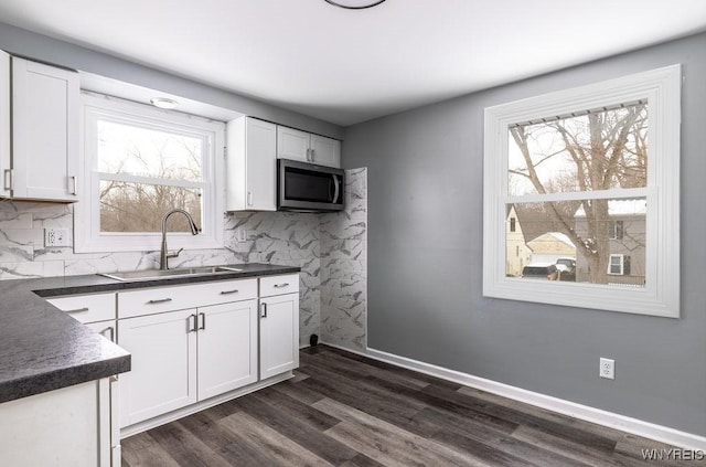 kitchen featuring dark hardwood / wood-style flooring, sink, tasteful backsplash, and white cabinets