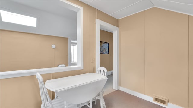 dining space with lofted ceiling and carpet flooring