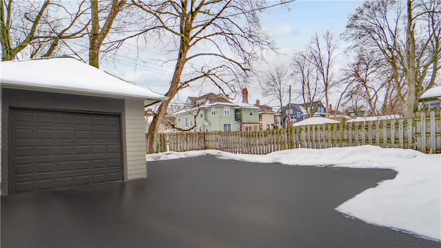 snowy yard featuring a garage