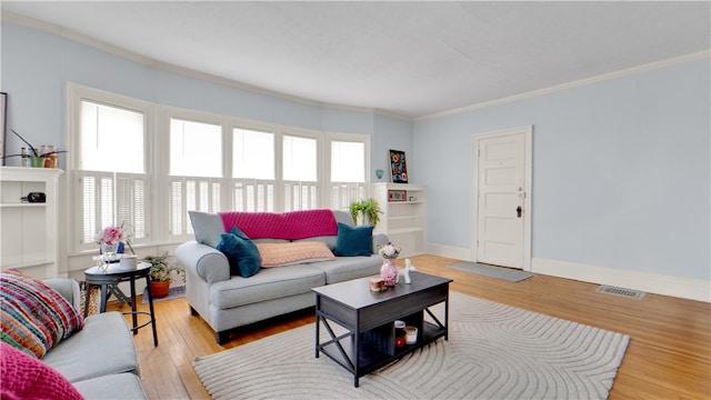 living room with light wood-type flooring and ornamental molding