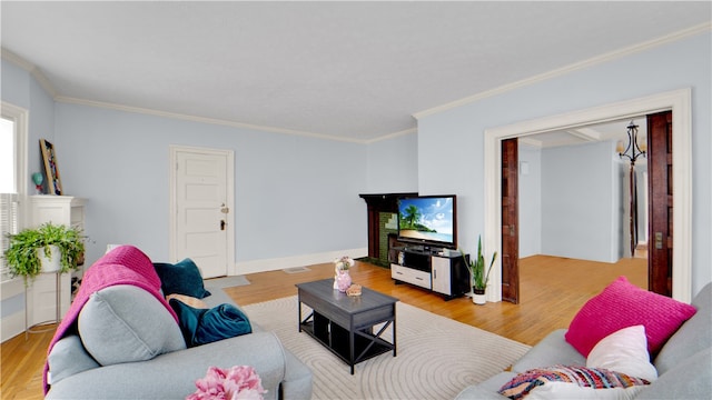 living room with light hardwood / wood-style flooring and crown molding