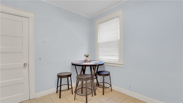 dining area with light tile patterned floors and crown molding