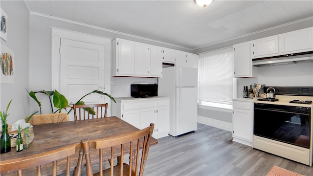 kitchen featuring white fridge, gas range oven, light hardwood / wood-style floors, crown molding, and white cabinets