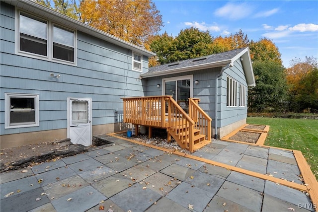 back of property featuring a deck, a lawn, and a patio area