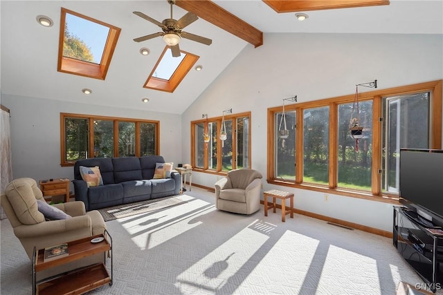 living room with a skylight, ceiling fan, high vaulted ceiling, beamed ceiling, and light colored carpet