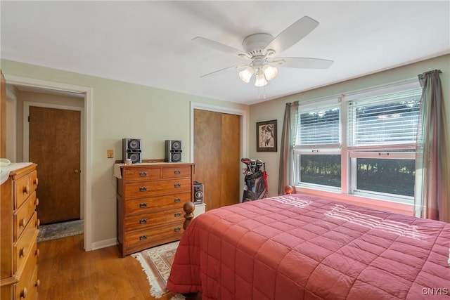 bedroom with ceiling fan, a closet, and wood-type flooring