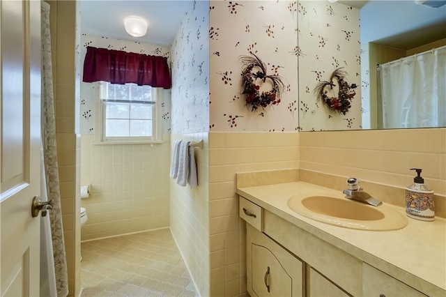 bathroom with tile walls, vanity, and toilet