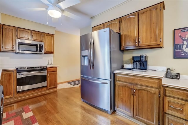 kitchen with ceiling fan, light wood-type flooring, and stainless steel appliances