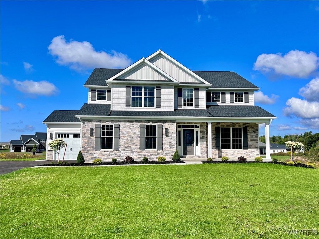 craftsman-style home with covered porch, a front lawn, and a garage