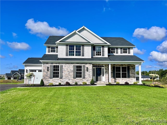 craftsman-style home with covered porch, a front lawn, and a garage