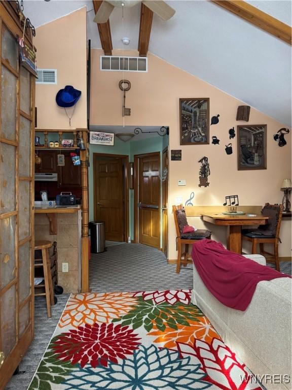 carpeted living area with lofted ceiling with beams, visible vents, and a ceiling fan