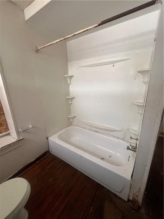 bathroom featuring hardwood / wood-style flooring, tub / shower combination, and toilet