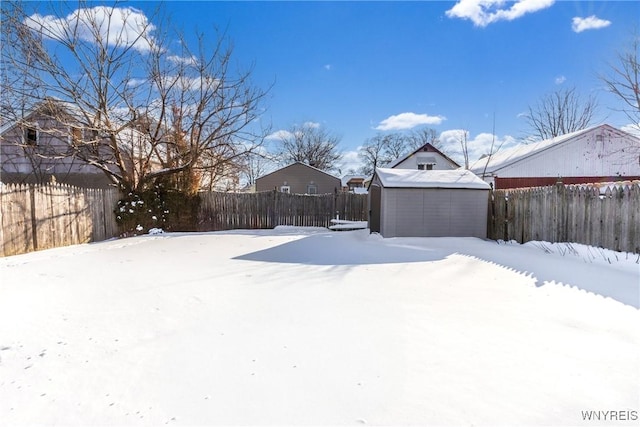 yard covered in snow with a storage shed