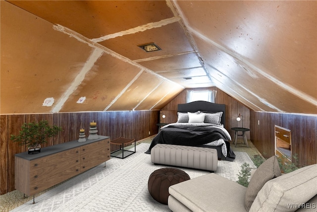 bedroom featuring lofted ceiling and wood walls