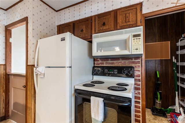 kitchen with ornamental molding and white appliances