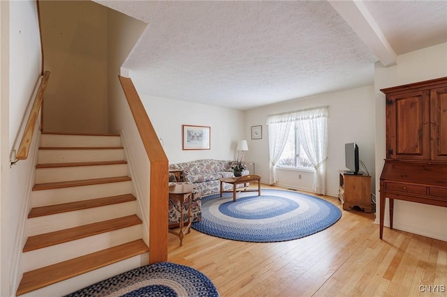 living area featuring light hardwood / wood-style flooring and a textured ceiling