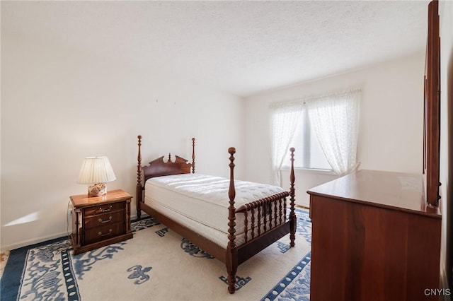 bedroom featuring a textured ceiling and light colored carpet