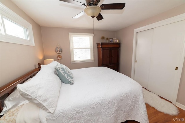 bedroom with ceiling fan, a closet, and wood-type flooring