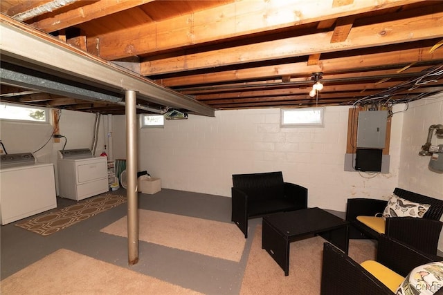 basement with washing machine and dryer, electric panel, and a wealth of natural light