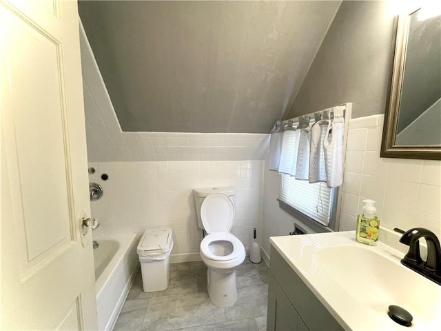 bathroom featuring tile walls, toilet, vanity, and vaulted ceiling