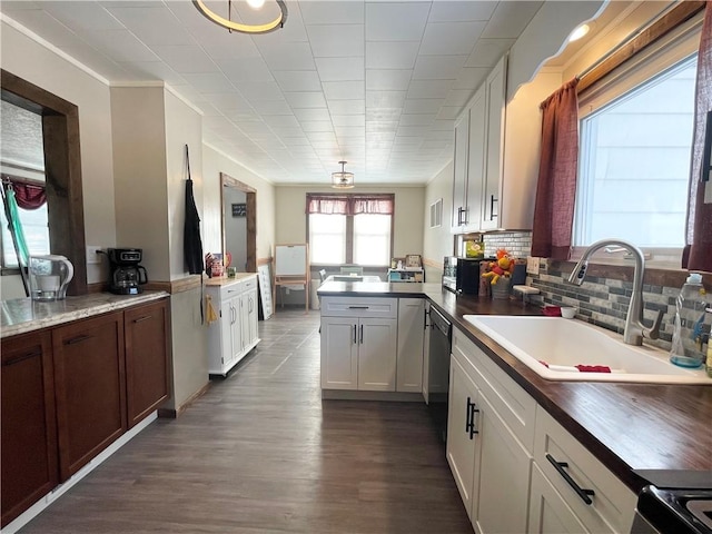 kitchen featuring sink, white cabinetry, dishwasher, kitchen peninsula, and decorative backsplash