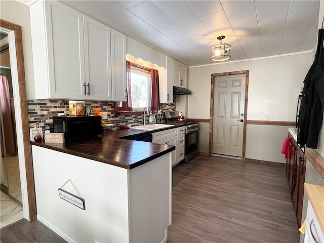 kitchen with sink, white cabinetry, stainless steel gas range oven, hardwood / wood-style flooring, and tasteful backsplash