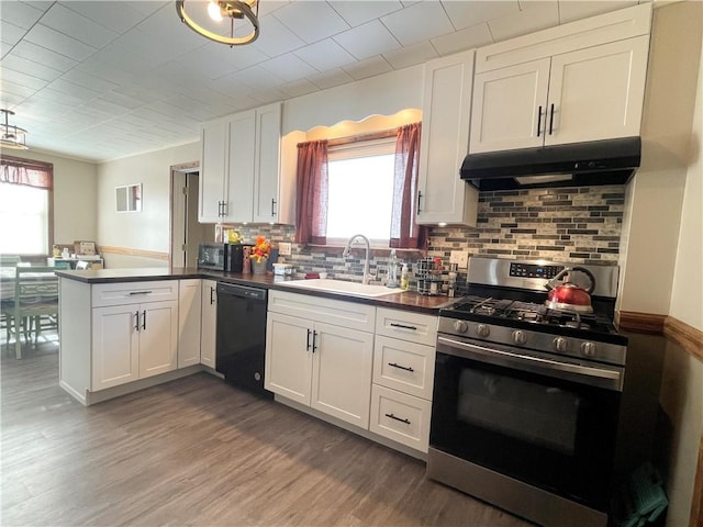 kitchen with stainless steel range with gas cooktop, kitchen peninsula, black dishwasher, sink, and white cabinets