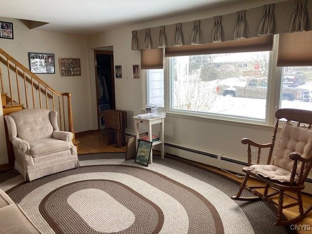 1612 Copperfield St, Utica, NY 13501 - living area with a baseboard radiator and stairway