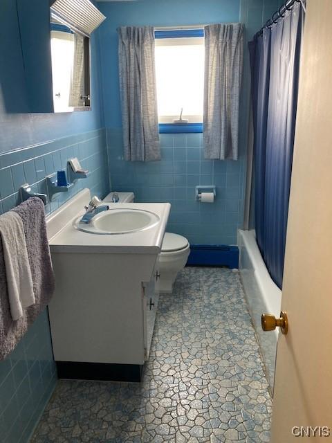 1612 Copperfield St, Utica, NY 13501 - full bathroom featuring toilet, vanity, a wealth of natural light, and tile walls
