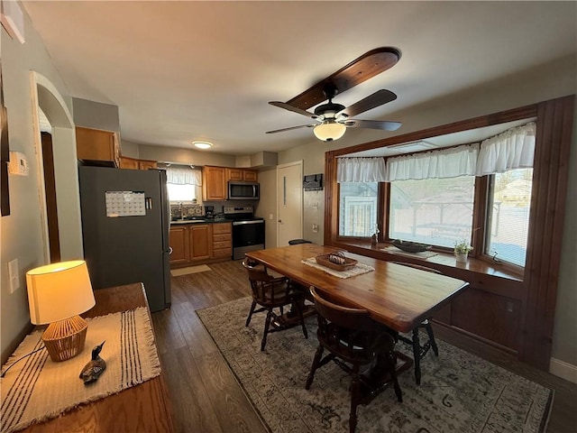 dining area with sink, ceiling fan, dark hardwood / wood-style flooring, and a healthy amount of sunlight