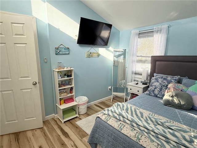 bedroom with light hardwood / wood-style floors and lofted ceiling