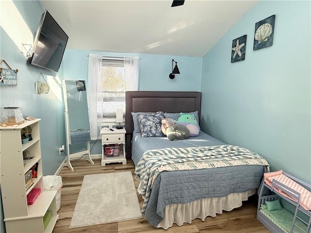 bedroom with hardwood / wood-style flooring and lofted ceiling