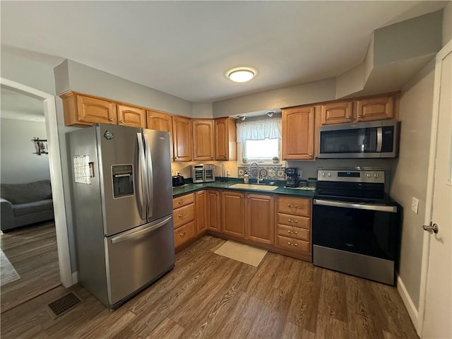 kitchen featuring sink, dark wood-type flooring, and stainless steel appliances