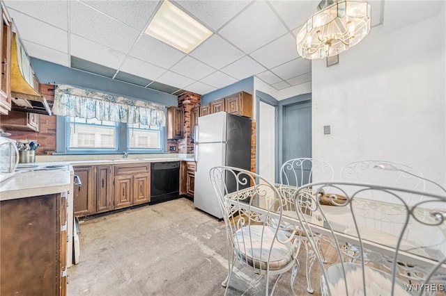 kitchen with a drop ceiling, dishwasher, hanging light fixtures, and fridge