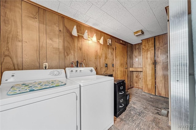 laundry room with wooden walls and washing machine and clothes dryer