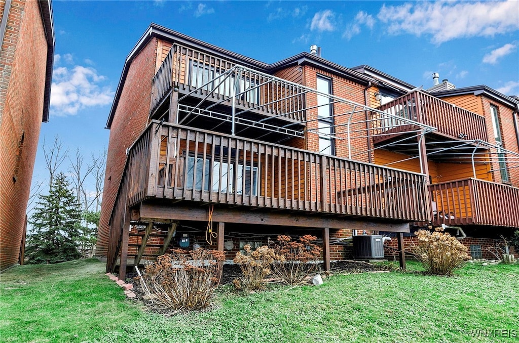 back of property with central AC, a wooden deck, and a yard