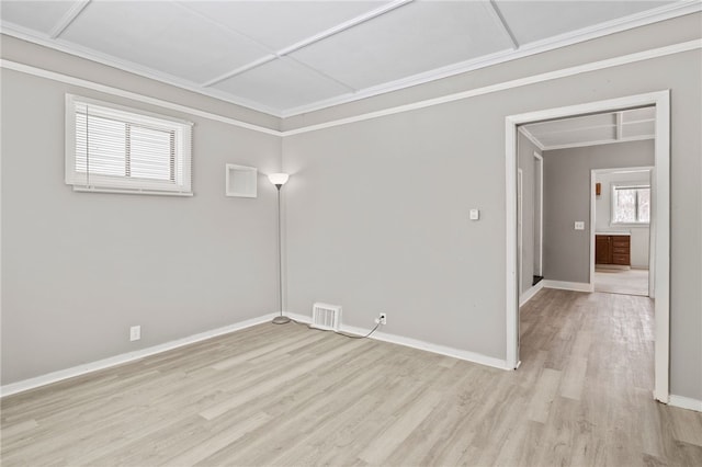 unfurnished room with baseboards, ornamental molding, visible vents, and light wood-style floors