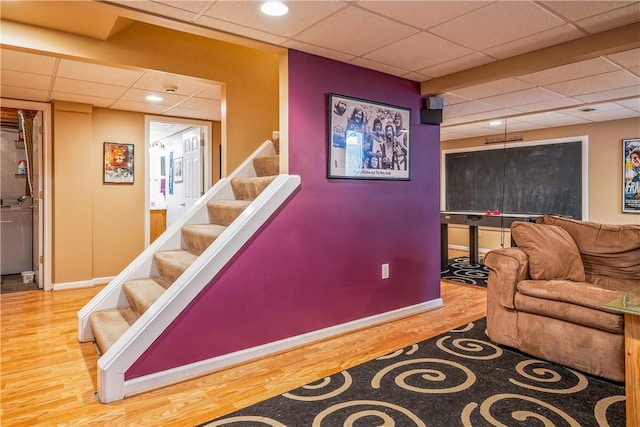 interior space featuring a paneled ceiling and hardwood / wood-style floors