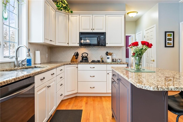 kitchen with white cabinetry, sink, and black appliances