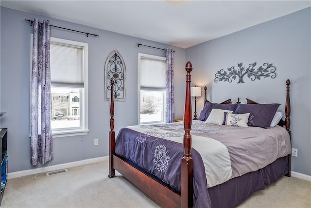 bedroom with multiple windows and light colored carpet