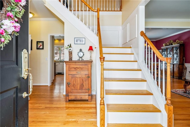 stairway featuring hardwood / wood-style flooring and ornamental molding