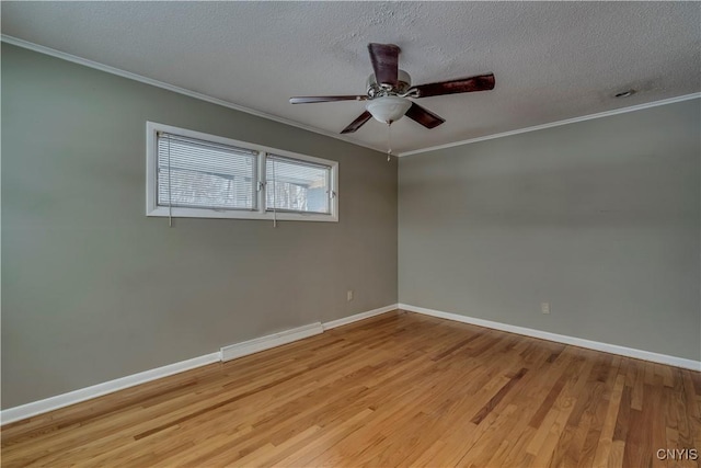 spare room featuring light hardwood / wood-style flooring, crown molding, a textured ceiling, and a baseboard heating unit