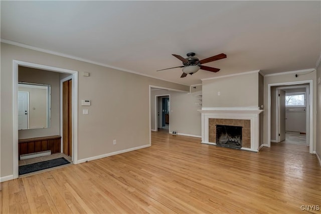 unfurnished living room with a tile fireplace, light wood-type flooring, ceiling fan, and ornamental molding