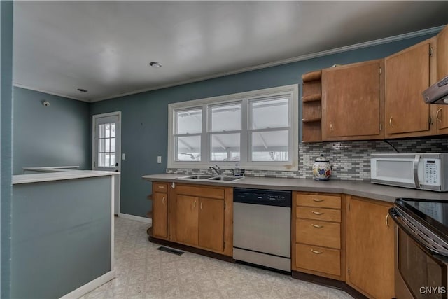 kitchen with appliances with stainless steel finishes, sink, ornamental molding, and tasteful backsplash