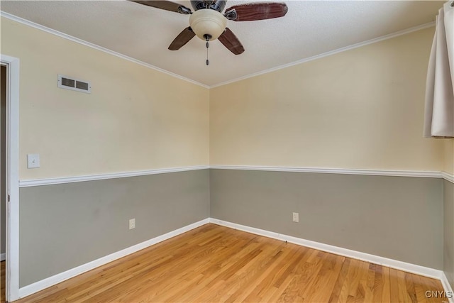 empty room with ornamental molding, hardwood / wood-style floors, and ceiling fan