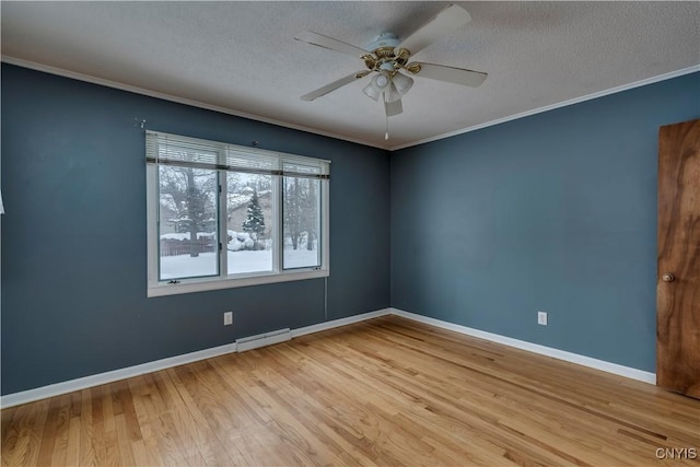 empty room featuring ceiling fan, ornamental molding, light wood-type flooring, and a textured ceiling