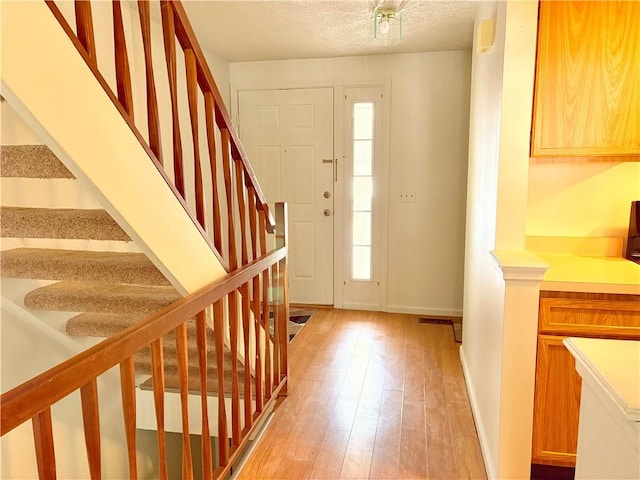 foyer featuring light hardwood / wood-style flooring and a textured ceiling