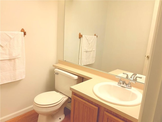 bathroom featuring toilet, wood-type flooring, and vanity