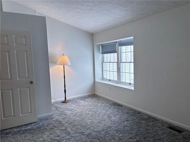 unfurnished room featuring carpet floors and a textured ceiling