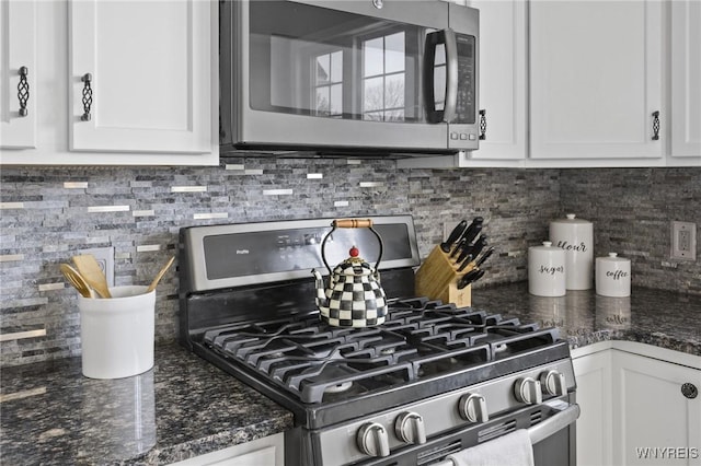 kitchen with dark stone counters, appliances with stainless steel finishes, white cabinets, and tasteful backsplash